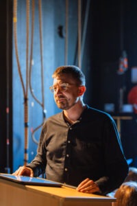 Choir conductor reviewing sheet music backstage before the concert. Photo by Assemble Photography.